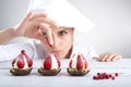 Woman pastry chef decorates strawberry cakes