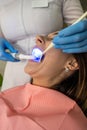 Woman patient receive procedure for teeth whitening bleaching with uv lamp Royalty Free Stock Photo