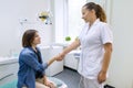 Woman patient shaking hand of female dentist having visit in medical clinic. Medicine, dentistry and healthcare concept