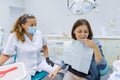 Woman patient sitting in dental chair with glass of water Royalty Free Stock Photo