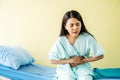 Woman patient  suffering from stomach ache while sitting on bed at hospital, abdominal pain, food poisoning Royalty Free Stock Photo