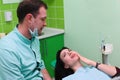 Woman patient talking to male dentist and complain of toothache at dental clinic office