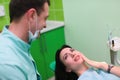 Woman patient talking to male dentist and complain of toothache at dental clinic office