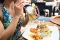 Woman patron eating seafood and drinking cocktail in restaurant