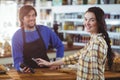 Woman paying bill through smartphone using NFC technology Royalty Free Stock Photo