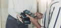 Woman paying bill through smartphone using NFC technology in a coffee. customer paying through mobile phone using contactless Royalty Free Stock Photo