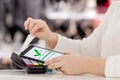 Woman paying bill through smartphone using NFC technology in restaurant, cafe, bar Royalty Free Stock Photo