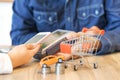 Woman paying for a new car via smartphone with red shopping cart Royalty Free Stock Photo