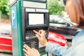 Woman paying for parking using terminal in the street Royalty Free Stock Photo