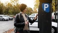 Woman Pays For Parking At Meter Royalty Free Stock Photo