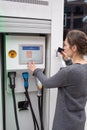 Woman pays at an electric car charging station