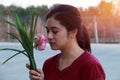 Woman peacefully smelling the pink lotus in bouquet.