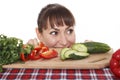 Woman peek out from the table with vegetables
