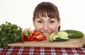 Woman peek out from the table with vegetables