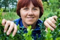 Woman peeking through green leafs