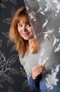 Woman peeking out from behind curtains in studio Royalty Free Stock Photo