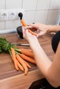 Woman peeling carrots in the kitchen Royalty Free Stock Photo