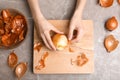 Woman peeling onion at table