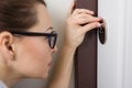 Woman is peeping at the keyhole, at home in the front door Royalty Free Stock Photo