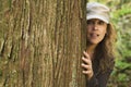 Woman peering around tree Royalty Free Stock Photo