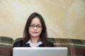 Woman with pen and laptop on sofa Royalty Free Stock Photo