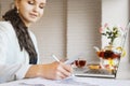 Woman with pen make notes on paper with chart. Focused hand with pencil