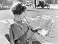 Woman with a pencil in her mouth reading the newspaper Royalty Free Stock Photo