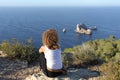 Woman pensive relaxing on a cliff in Ibiza island