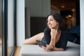 Woman with perfect body in black bodysuit lying on mattress near big window on vacation at lounge zone in the spa resort Royalty Free Stock Photo