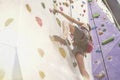 Woman with perfect fit body training on a climbing wall in sport hall, ready to workout. Royalty Free Stock Photo