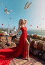 Woman with perfect legs in a long red dress posing with flying seagulls at the traditional Turkish balcony near OrtakÃÂ¶y mosque Royalty Free Stock Photo