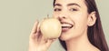 Stomatology concept. Woman with perfect smile holding apple, blue background. Woman eat green apple. Portrait of young Royalty Free Stock Photo