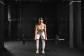 Woman performing deadlift as strength exercise. Lifting barbell off the ground. Routine workout for physical and mental