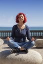 Woman performing joga on energy stones near sea coast Royalty Free Stock Photo