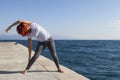 Woman performing joga on sea coast