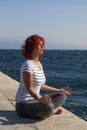 Woman performing joga on sea coast