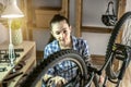 Woman is performing maintenance on his mountain bike. Concept of fixing and preparing the bicycle for the new season