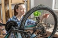 Woman is performing maintenance on his mountain bike. Concept of fixing and preparing the bicycle for the new season