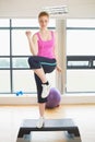 Woman performing step aerobics exercise Royalty Free Stock Photo