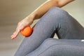 A woman performs myofascial relaxation of the leg muscles with a massage ball, close-up