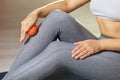 A woman performs myofascial release of the ankle muscles with a massage ball at home. The concept of preventing leg fatigue