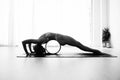 A woman performs the reverse plank with the help of the yoga wheel