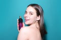 Woman with perfume bottle in studio. Girl with perfume, young beautiful woman holding bottle of perfume and smelling Royalty Free Stock Photo