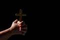 Woman person hand with jesus christ cross praying in dark background. Female christian worship to god in faith. Girl christian