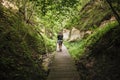 Woman person walking on hiking trail of Hinni canyon, cliff made out of an sand in Estonia.