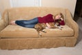 Woman petting dog on couch - dog is asleep