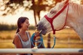 Woman petting a  horse on a ranch on a sunny summer day Royalty Free Stock Photo