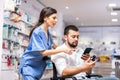 Woman pharmacist helping man in wheelchair to help choose medicine Royalty Free Stock Photo