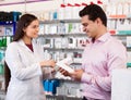 Woman pharmacist and visitor at the chemists shop