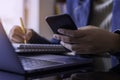 woman hand using mobile smart phone, work on laptop computer and writing note on paperwork Royalty Free Stock Photo